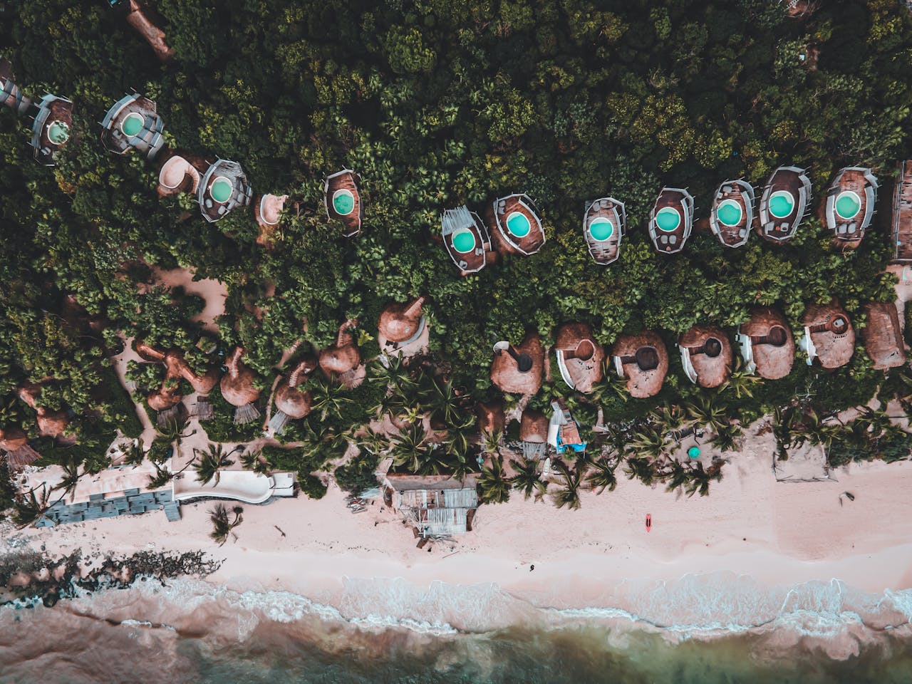 testimonial-img Stunning top-down view of a tropical beach resort with private pools and lush greenery.